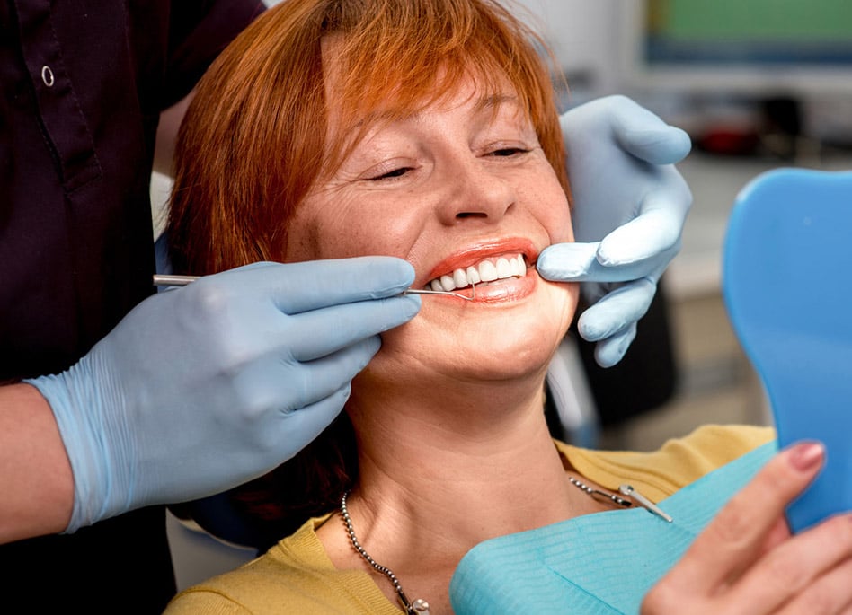 lady smiling with implant suported dentures